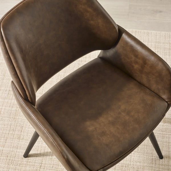 Brown leather chair on a textured beige floor