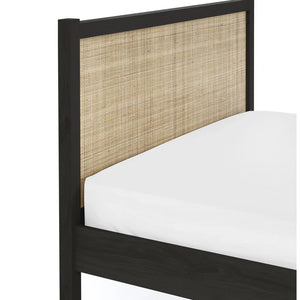 Bed with black frame and woven headboard on a white background