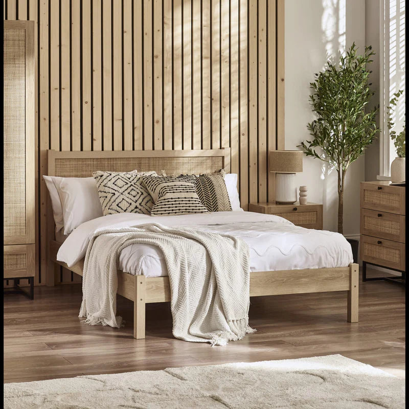 Wooden bed frame with woven headboard and white mattress on a white background