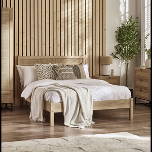 Bedroom with wooden bed, pillows, and a lamp against a wooden slat wall.