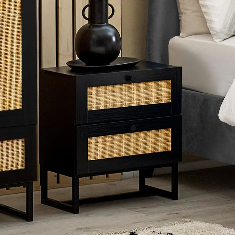 Black nightstand with rattan-like drawer fronts on a white background