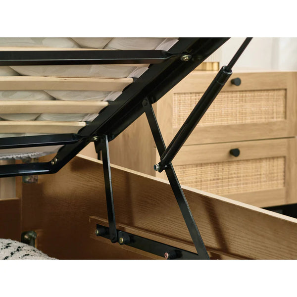 Metal bed frame with wooden drawers in the background