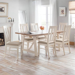 Dining room with a wooden table and white chairs on a wooden floor.
