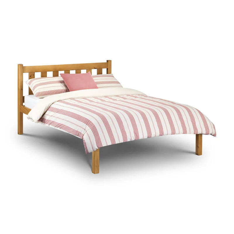Wooden bed with red and white striped bedding on a white background