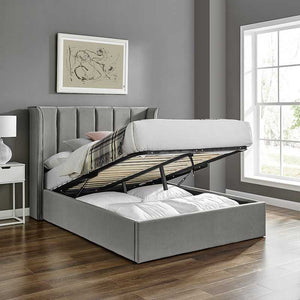 Gray upholstered bed with open storage drawers in a room with a window and wall art.