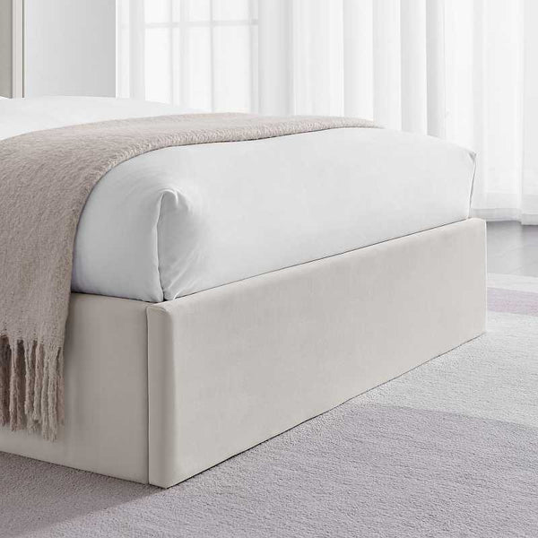 White bed with beige blanket in a minimalistic room