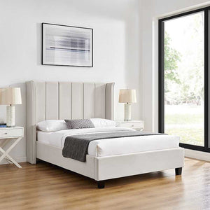 White upholstered bed in a modern bedroom with side tables and lamps.