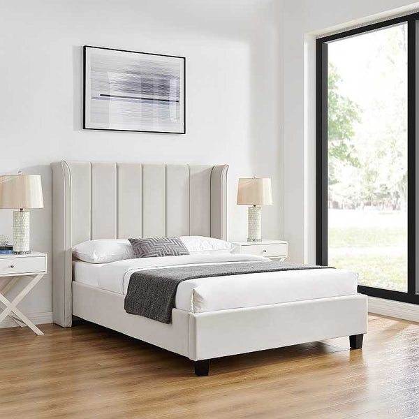 White upholstered bed in a modern bedroom with side tables and lamps.