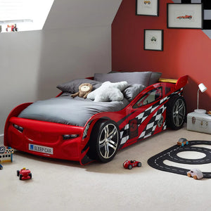 Red car-shaped bed in a child's bedroom with toys and decor.