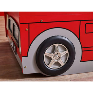 Close-up of a red toy bus with a black tire and silver rim on a wooden surface.