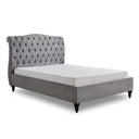 Gray tufted bed with white mattress on a white background
