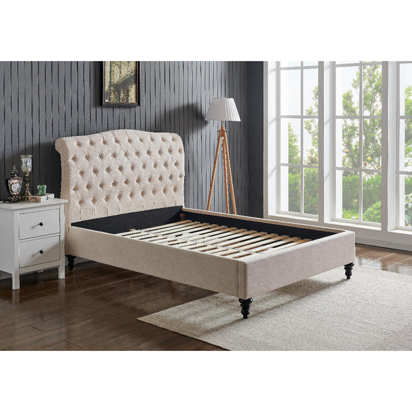 Beige upholstered bed with tufted headboard in a room with a window and side table.