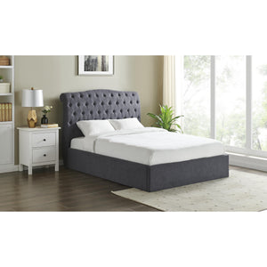 Gray upholstered bed in a bedroom setting with a nightstand and window.