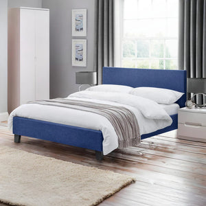 Blue upholstered bed in a bedroom setting with white bedding and gray striped blanket.