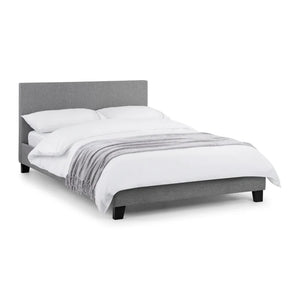 Gray upholstered bed with white bedding on a white background