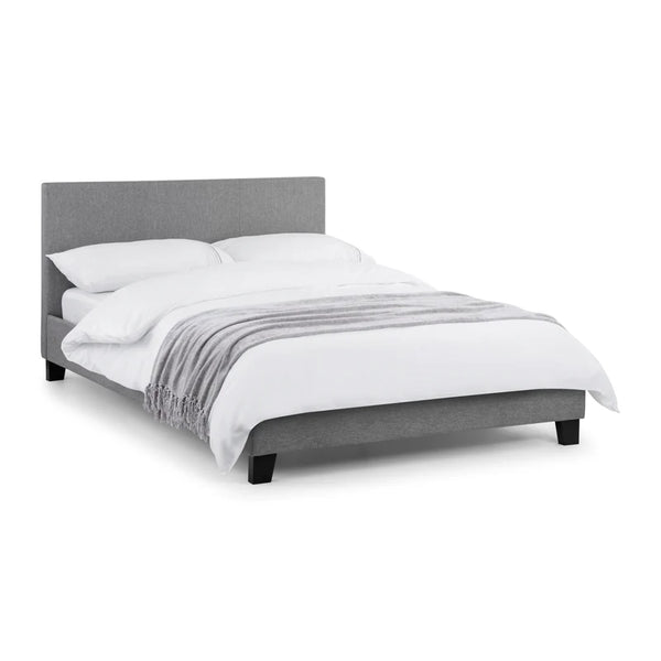 Gray upholstered bed with white bedding on a white background
