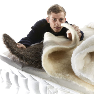 Man examining a roll of bed fillings on a white background