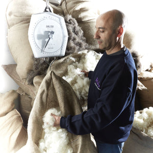 Man inspecting wool with a scale in a wool processing facility