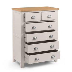 White dresser with multiple drawers and a wooden top on a white background