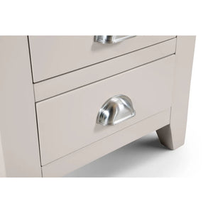 Close-up of a light gray dresser with a silver handle on a white background