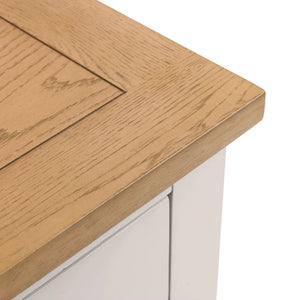 Close-up of a wooden table corner with a white base