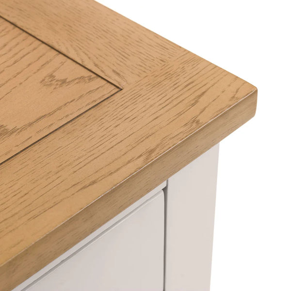 Close-up of a wooden table corner with a white base