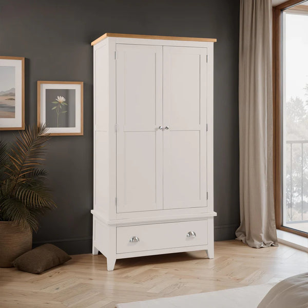 Grey wardrobe with wooden top in a room with dark walls, framed pictures, and a window.