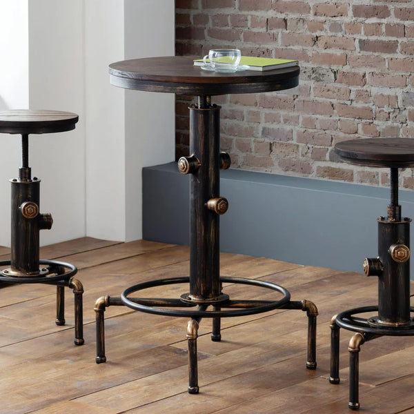  industrial-style table and barstoold with metal legs on a wooden floor against a brick wall.