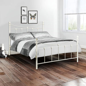 White metal bed with gray bedding in a bedroom setting