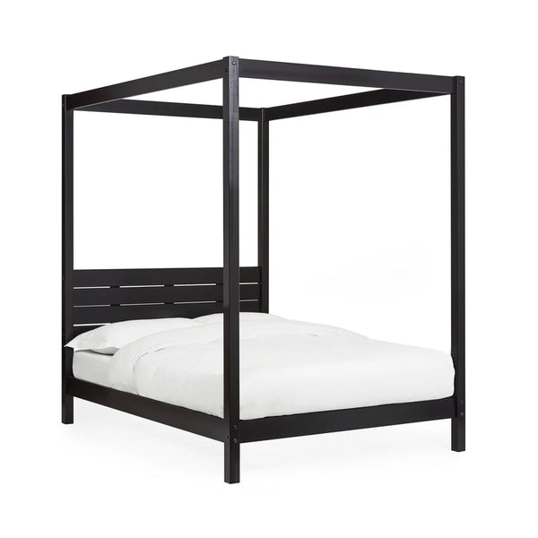 Black canopy bed with white bedding on a white background