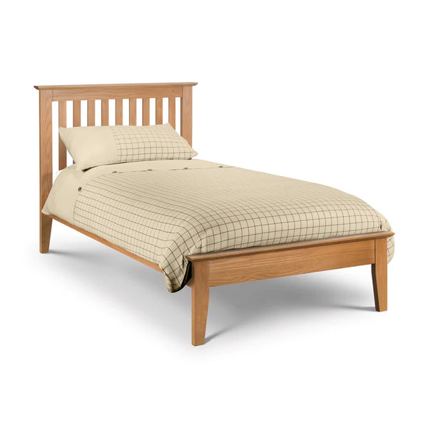 Wooden bed with beige bedding on a white background