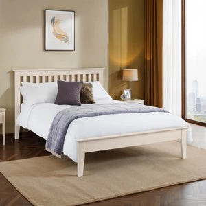 Bedroom with a wooden bed frame, white bedding, and decorative pillows.