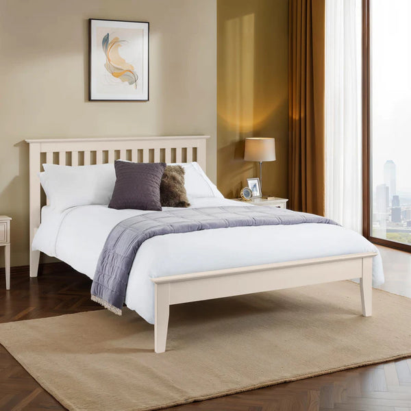 Bedroom with a wooden bed frame, white bedding, and decorative pillows.