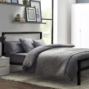 Bedroom with gray bedding on a bed, nightstands, and wall art.