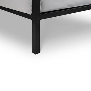 Close-up of a black metal bed frame corner on a white background