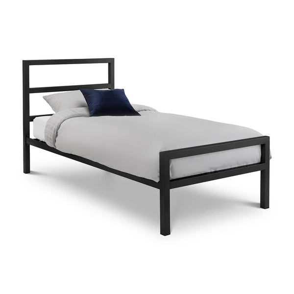 Black metal bed frame with white bedding and a blue pillow on a white background