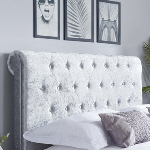 Gray tufted headboard with decorative pillows in a bedroom setting.