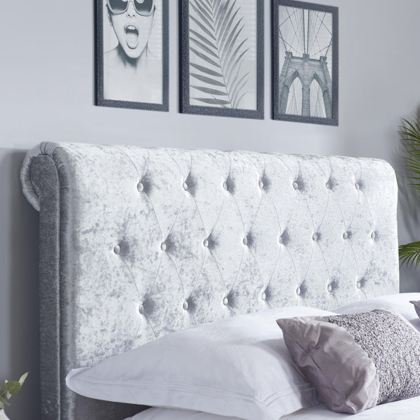 Gray tufted headboard with decorative pillows in a bedroom setting.