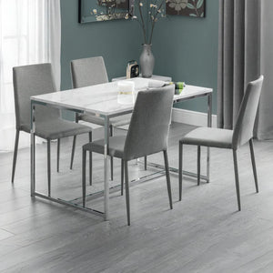 Dining room with a rectangular table and four gray chairs against a teal wall.