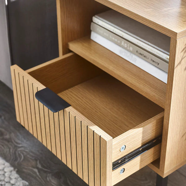 Wooden sideboard with open drawer and books on top