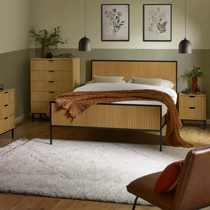 Bedroom with wooden bed frame, nightstands, and wall art