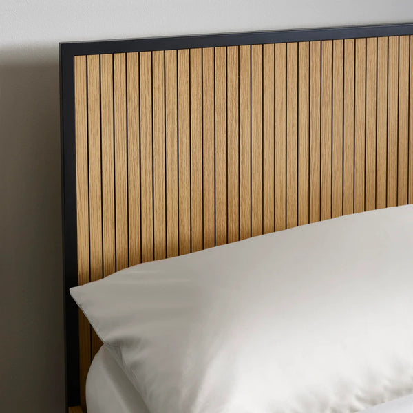 Wooden headboard with slatted design on a bed with white bedding.