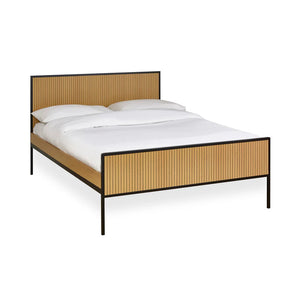 Bed with wooden frame and white bedding on a white background