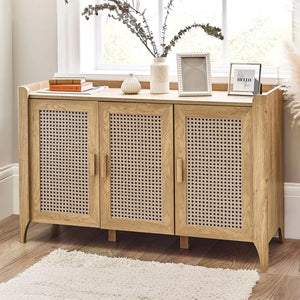 Wooden sideboard with rattan doors in a room with a window and decor items.