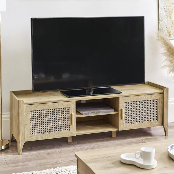 Wooden TV stand with a television on top in a room setting.
