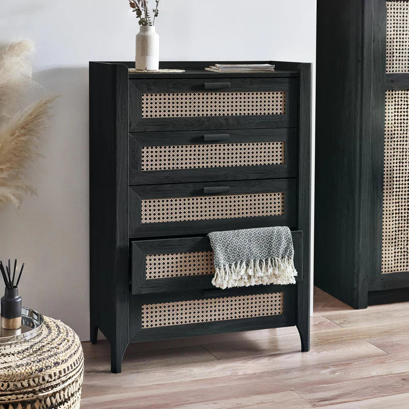 Black dresser with wicker drawer fronts on a white background