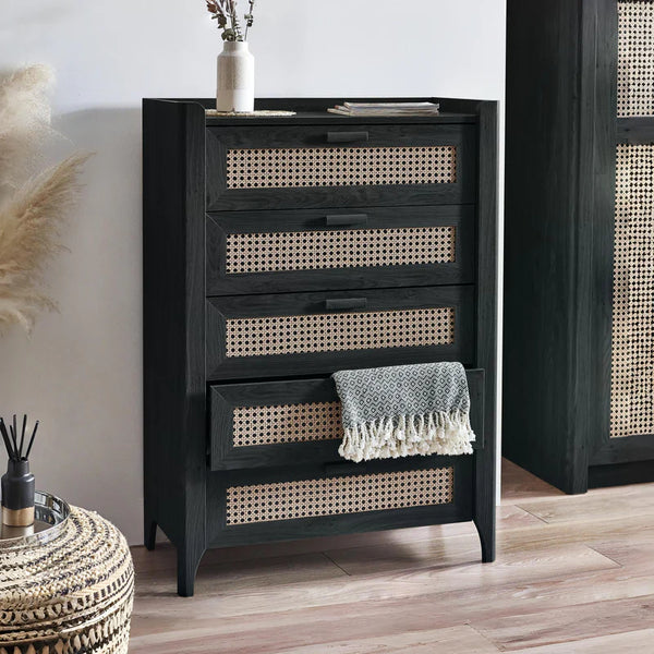 Black dresser with wicker drawers in a room setting