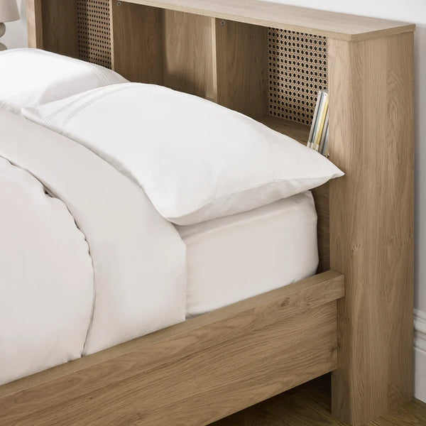 Wooden bed frame with white bedding and a headboard