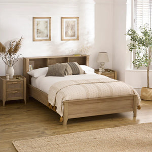 Wooden bed in a bedroom with side tables, lamps, and decorative elements.