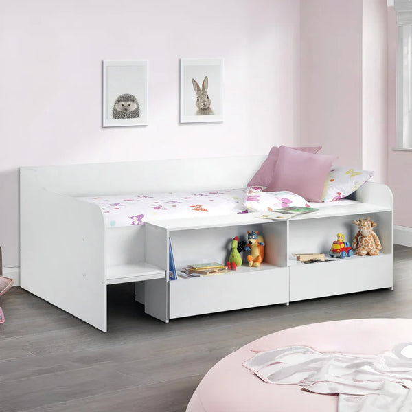 White children's bed with storage compartments and toys in a room with pink walls and a round pink chair.